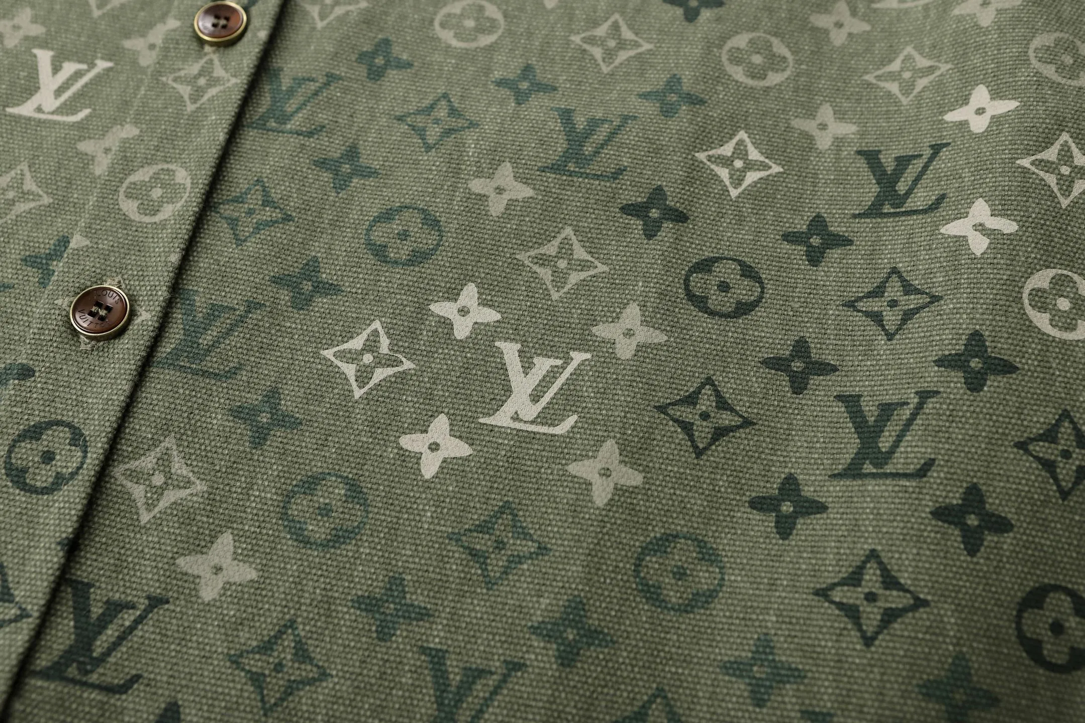 🅿️600 1v 25SS full-print green camouflage work jacket style shirt. The original purchase was 16,000 and developed. The fabric is made of custom-dyed 50-count plain double-ply pique cotton. Before positioning and cutting the fabric pieces, digital typesetting is used to lock the position of the full-print Monogram pattern to ensure that the pattern is continuous and without misalignment after splicing. The pattern alignment error between the body and the solid color splicing area is controlled within 0.5cm. The printing process uses digital direct injection technology: the pigment penetrates the fabric fibers with micron-sized particles, presenting a low-saturation vintage tone while maintaining the breathability of the fabric. The wear resistance of the printing layer reaches level 5 (friction test ≥ 200 times without falling off). The body is made of twill canvas blended fabric, and the splicing parts are reinforced with double-needle buried clip technology. The buttons are made of brass-plated matte paint, and the stitching is made of high-tenacity nylon thread with a tensile strength of 150N. The overall process takes into account both visual integrity and practical durability. The overall wiring is straight and delicate, the fabric is comfortable and soft, and the color is consistent without color difference. It can be matched with the same style to create a fashionable look and control various occasions. Customized accessories, complete with three standards, the same style for men and women. Size:S-M-L-XL